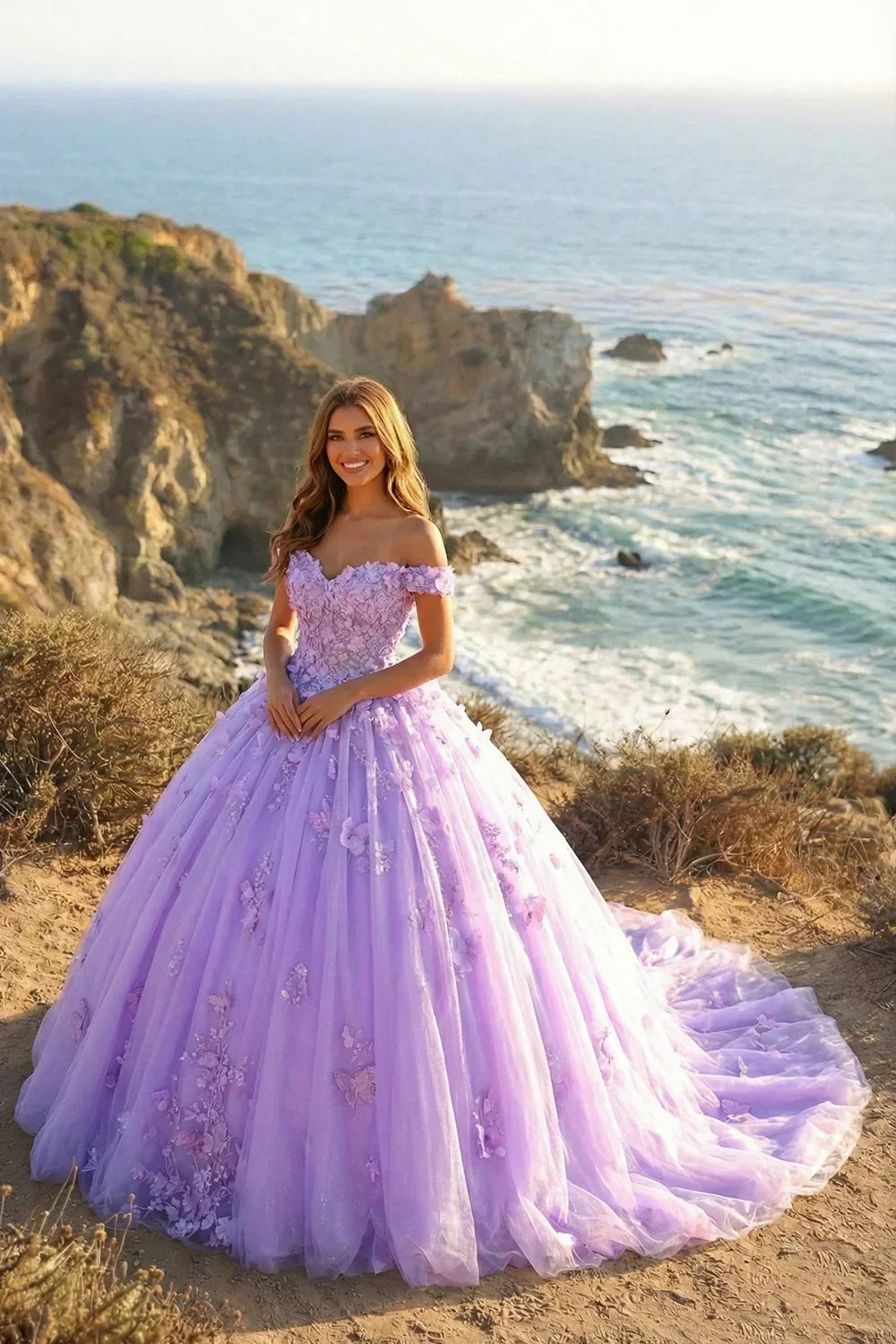 Woman in a lilac ball gown with 3D floral lace, off-shoulder, by the ocean cliffs