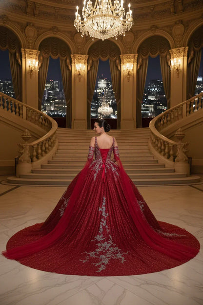 Woman in elegant red A-line off-the-shoulder tulle gown with silver embroidery in grand ballroom