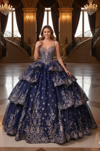 Woman in ornate navy blue layered ruffled ball gown with gold embroidery in grand hall