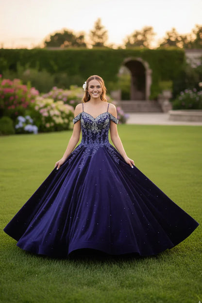 Elegant navy blue lace ball gown with cold shoulder design and sparkle details, worn outdoors