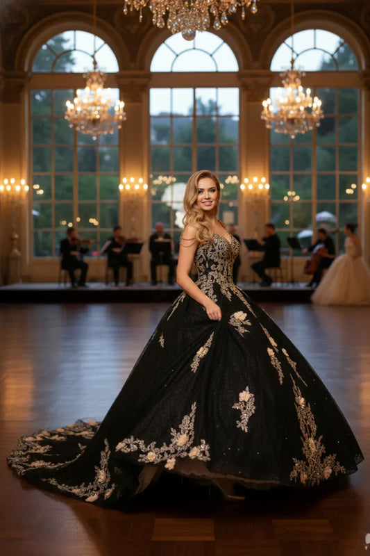 Woman in black floral ball gown with beading, posed in elegant ballroom with chandeliers