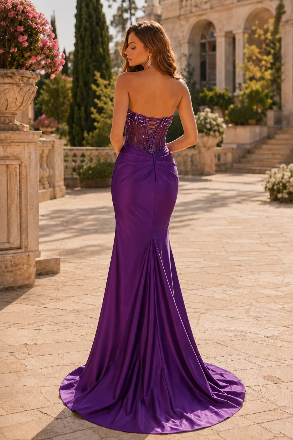 Deep Plum strapless embellished corset prom gown with a slit, back view